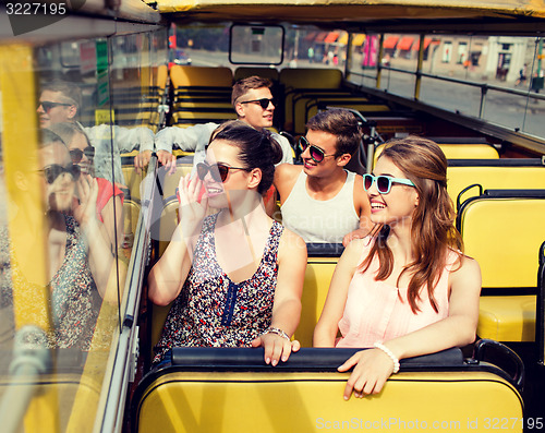 Image of group of smiling friends traveling by tour bus