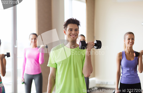 Image of group of smiling people working out with dumbbells