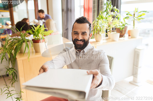 Image of happy creative male office worker with folfer