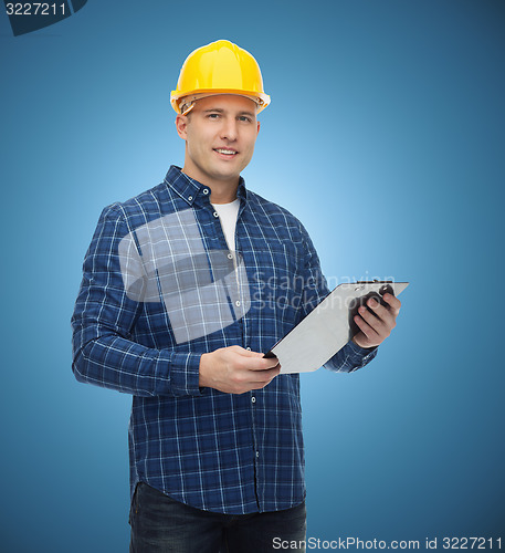 Image of smiling male builder in helmet with clipboard
