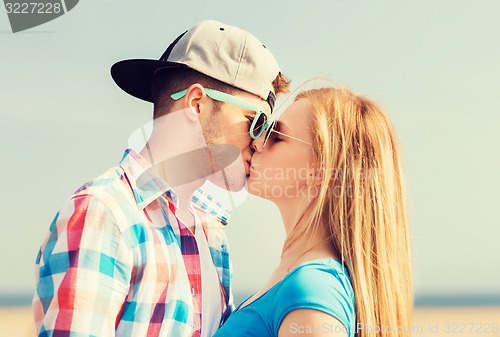 Image of teenage couple kissing outdoors