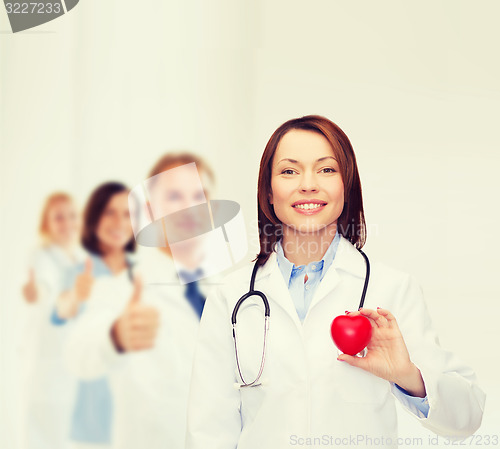 Image of smiling female doctor with heart and stethoscope