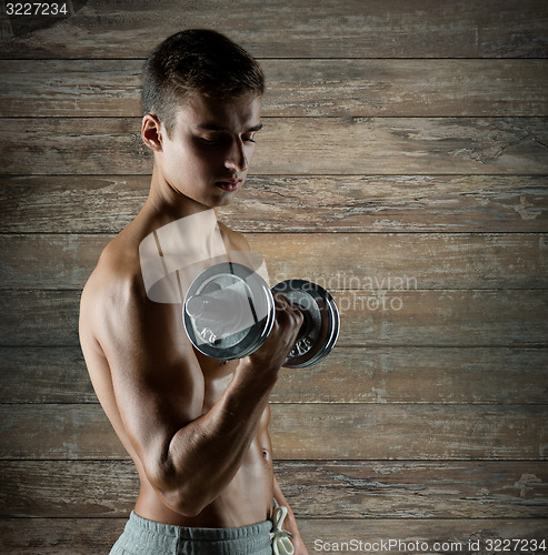 Image of young man with dumbbell flexing biceps