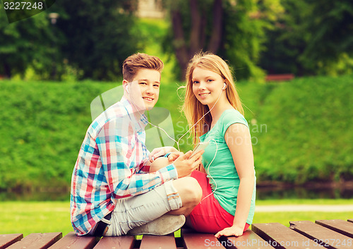 Image of smiling couple with smartphone and earphones