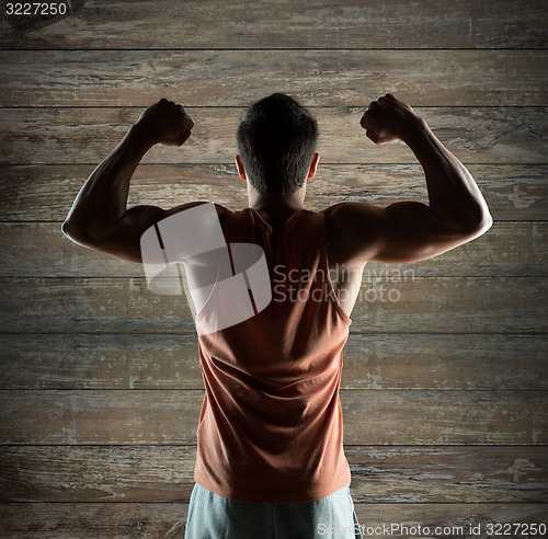 Image of young man or bodybuilder showing biceps