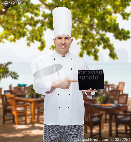 Image of happy male chef cook showing with tablet pc