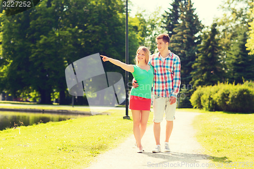 Image of smiling couple walking in park