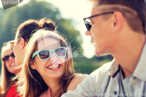 Image of group of smiling friends sitting on city street