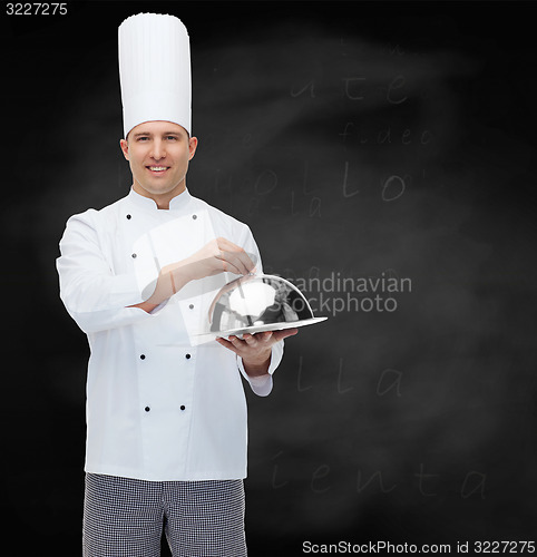 Image of happy male chef cook holding cloche