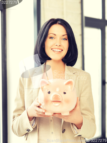 Image of lovely woman with piggy bank