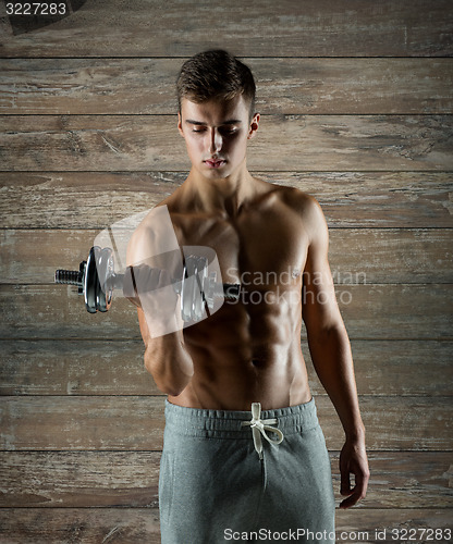 Image of young man with dumbbell flexing biceps