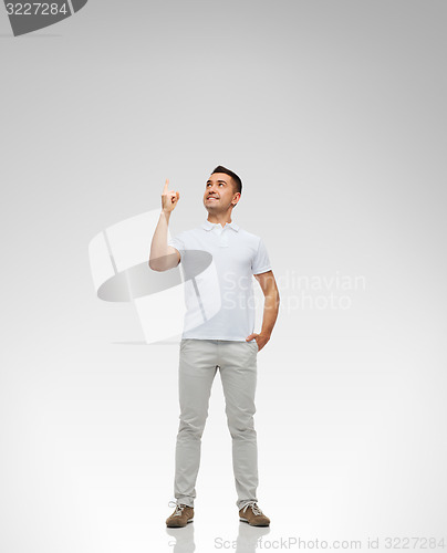 Image of smiling man pointing finger up