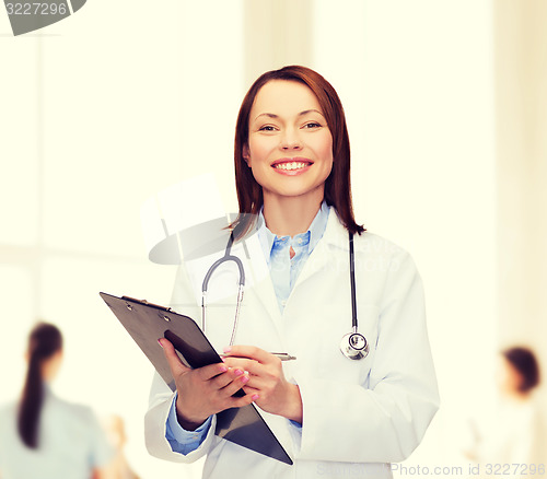 Image of smiling female doctor with clipboard