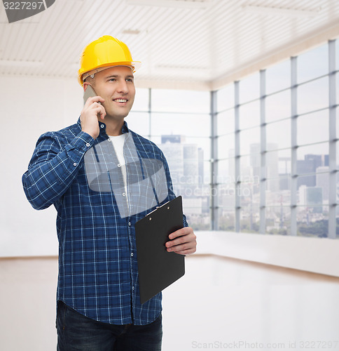 Image of smiling male builder in helmet with clipboard