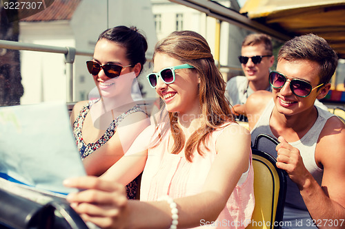 Image of group of smiling friends traveling by tour bus