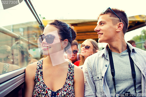 Image of smiling couple with camera traveling by tour bus