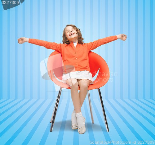 Image of happy little girl sitting on designer chair