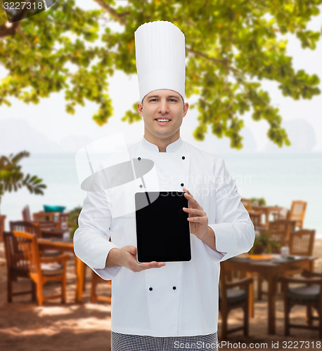 Image of happy male chef cook showing with tablet pc