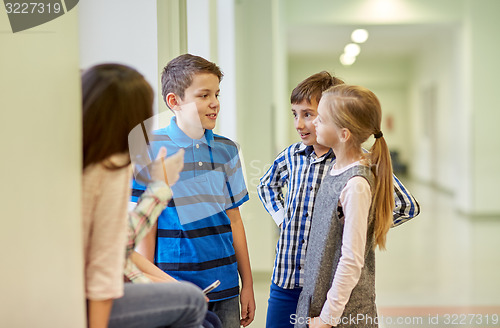 Image of group of smiling school kids talking in corridor