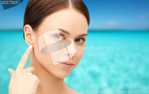 Image of face of beautiful woman touching her ear