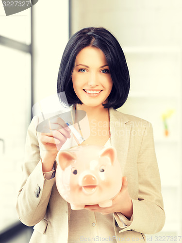 Image of lovely woman with piggy bank and money