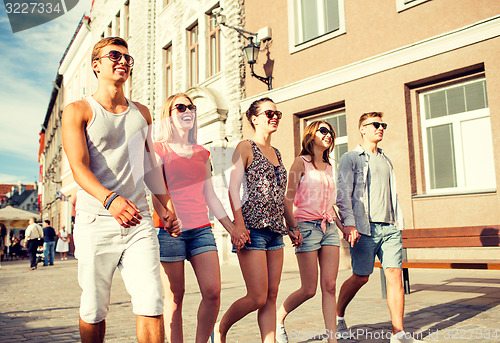Image of group of smiling friends walking in city