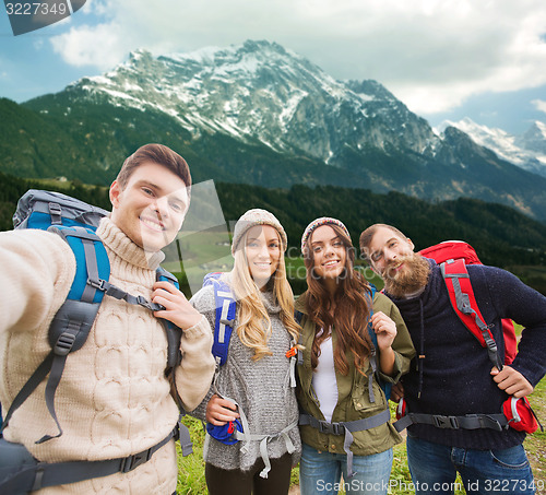 Image of group of smiling friends with backpacks hiking