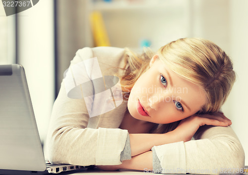 Image of bored and tired woman behind the table