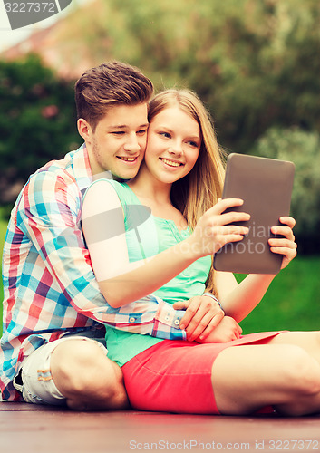 Image of smiling couple with tablet pc making selfie