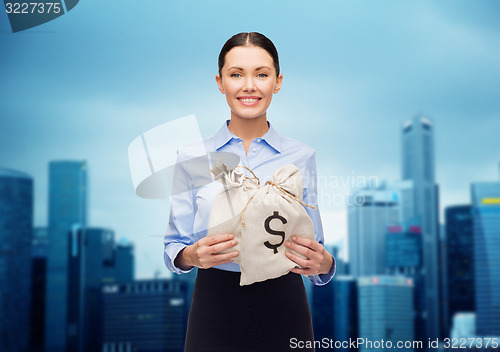Image of businesswoman holding money bags with euro