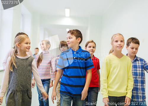 Image of group of smiling school kids walking in corridor