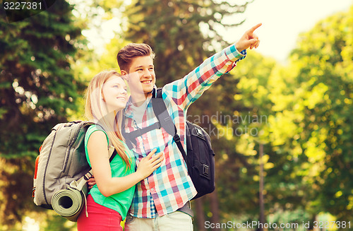 Image of smiling couple with backpacks in nature