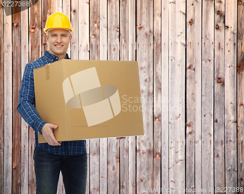 Image of smiling male builder in helmet with cardboard box