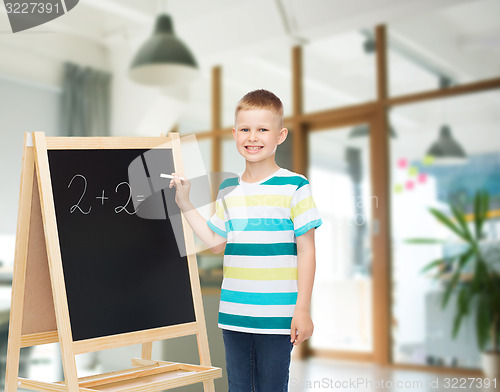 Image of happy little boy with blackboard and chalk