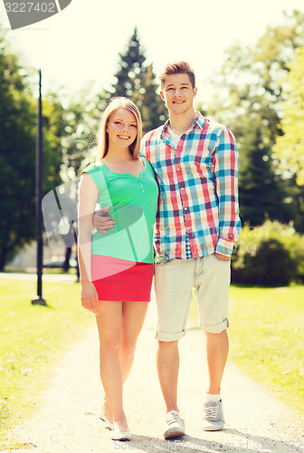Image of smiling couple walking in park