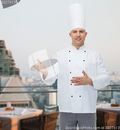 Image of happy male chef cook inviting