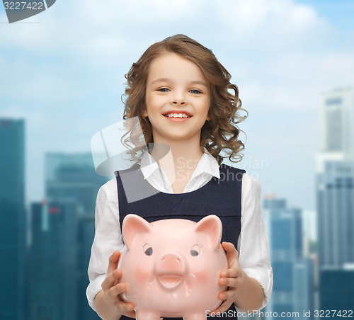 Image of happy girl holding piggy bank 