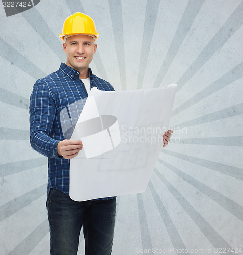 Image of smiling male builder in helmet with blueprint