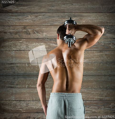 Image of young man with dumbbell flexing biceps