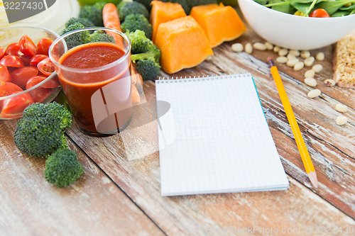 Image of close up of ripe vegetables and notebook on table