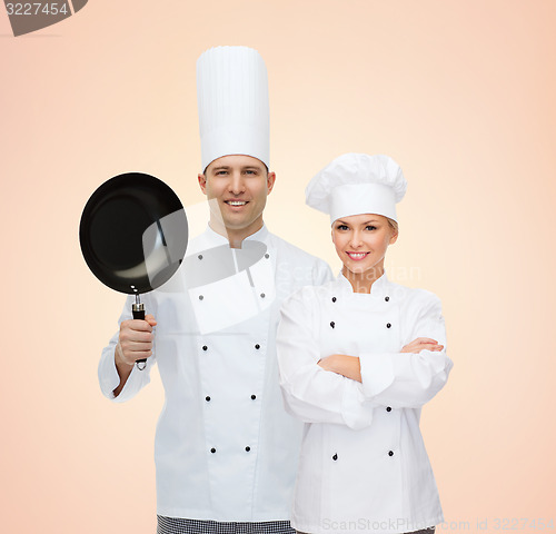 Image of happy chefs or cooks couple with frying pan