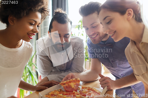 Image of happy business team eating pizza in office