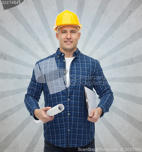 Image of smiling male builder in helmet with blueprint