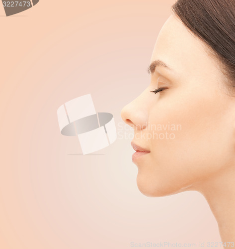 Image of beautiful young woman face over beige background