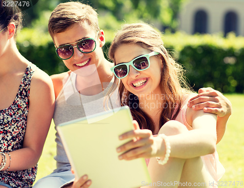 Image of smiling friends with tablet pc computers in park