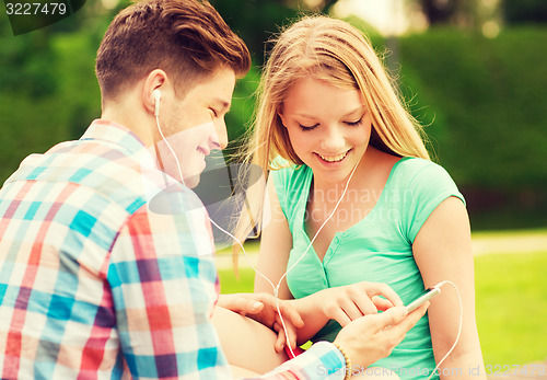 Image of smiling couple with smartphone and earphones