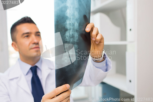 Image of close up of doctor in white coat looking at x-ray