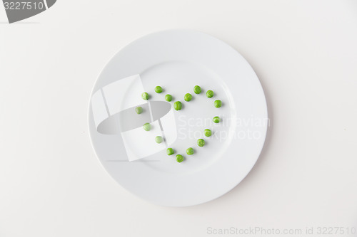 Image of close up of plate with peas  in heart shape 