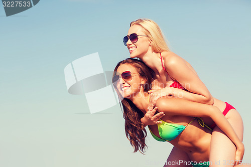 Image of two smiling young women on beach