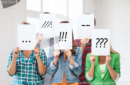 Image of friends or students covering faces with papers